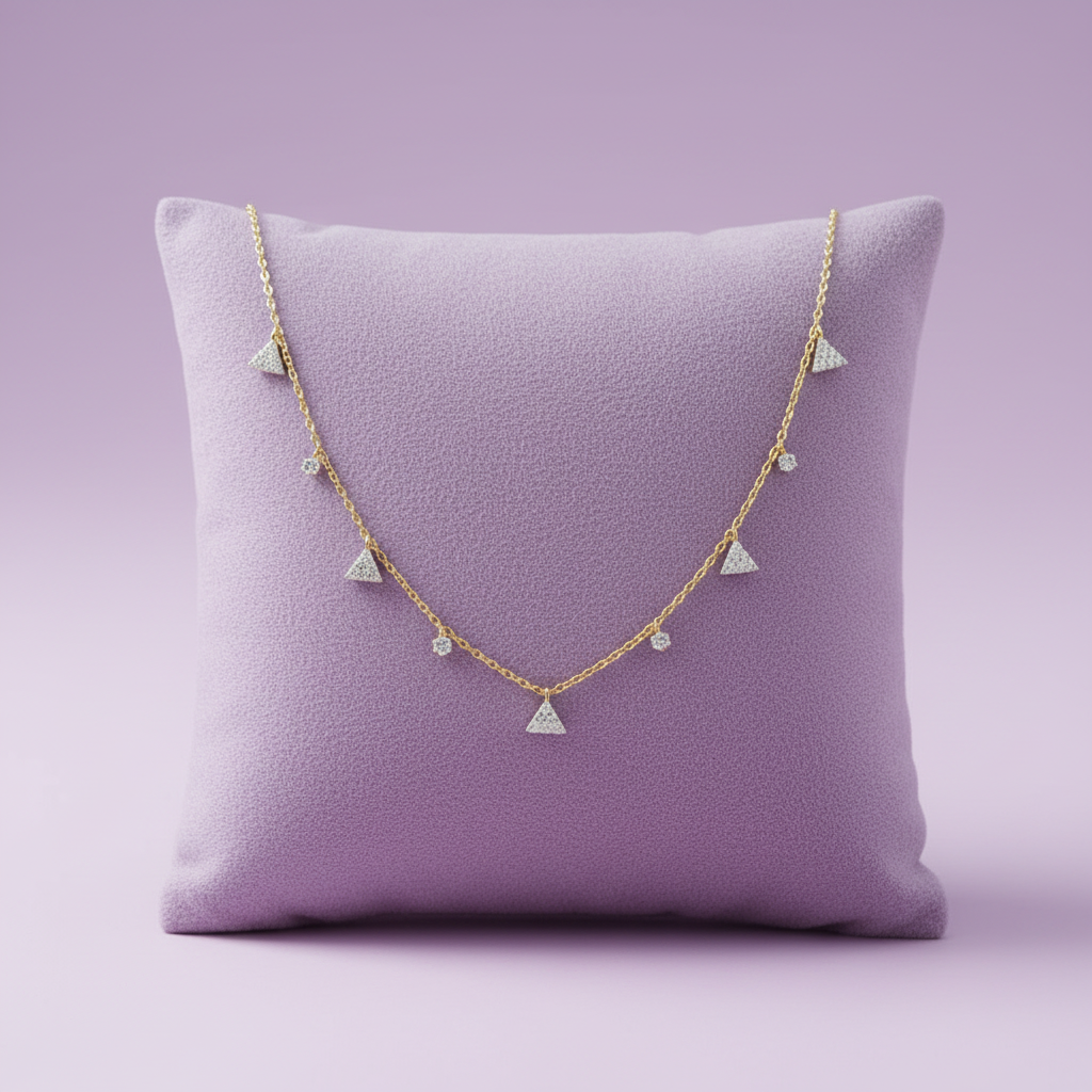 Exact yellow gold diamond triangle station necklace on lavender velvet cushion