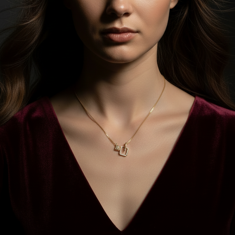 Model with open hair in dark outfit wearing geometric pendant